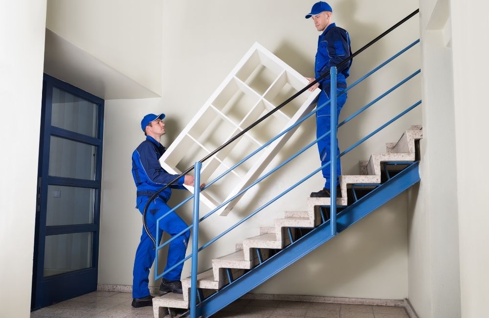 Movers moving furniture using stair