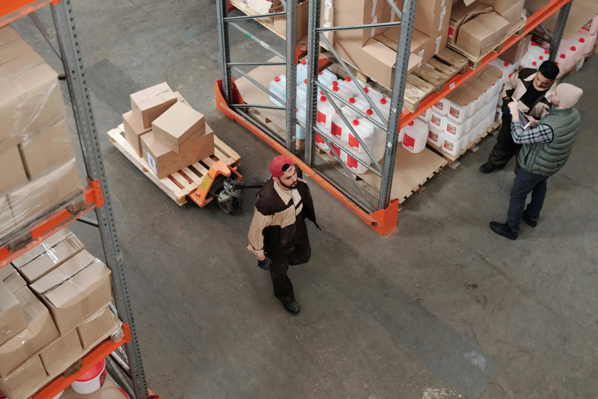 Warehouse staff organizing boxes and plastic containers on shelves