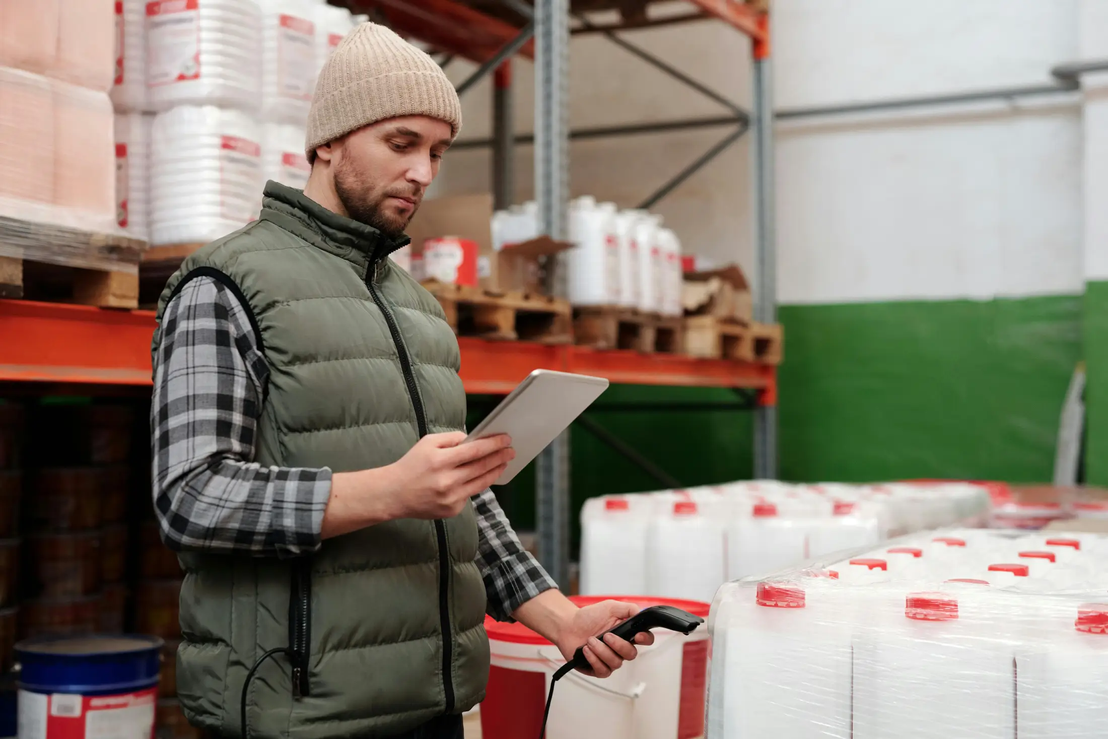 Warehouse worker using a tablet and barcode scanner to check inventory