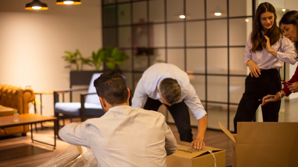 office employees unpacking cardboard boxes