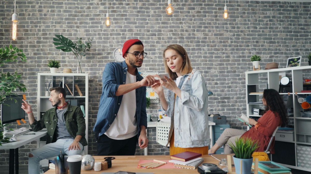 Colleagues working together and looking at a smartphone